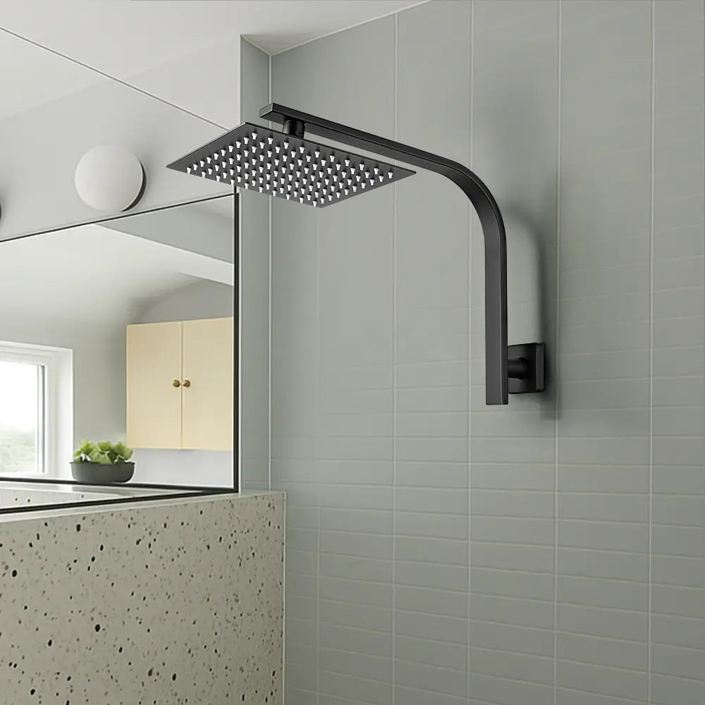 Black shower head mounted on a tiled bathroom wall