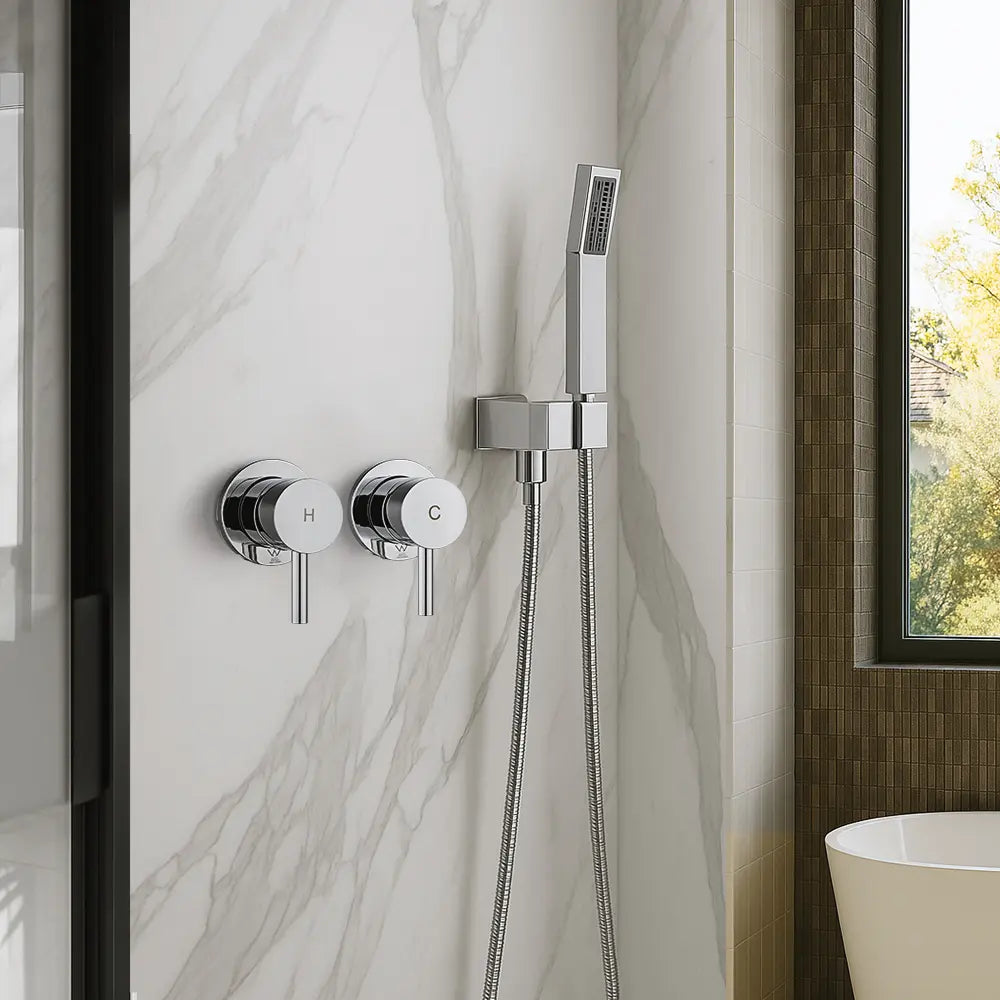 Chrome shower control panel with handheld shower head on a marble wall.