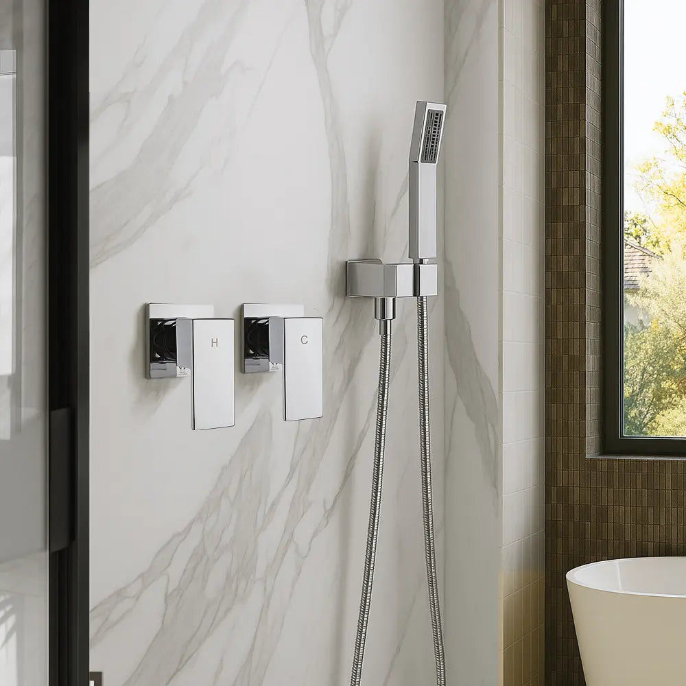 Chrome shower control panel and handheld shower head mounted on a marble wall.