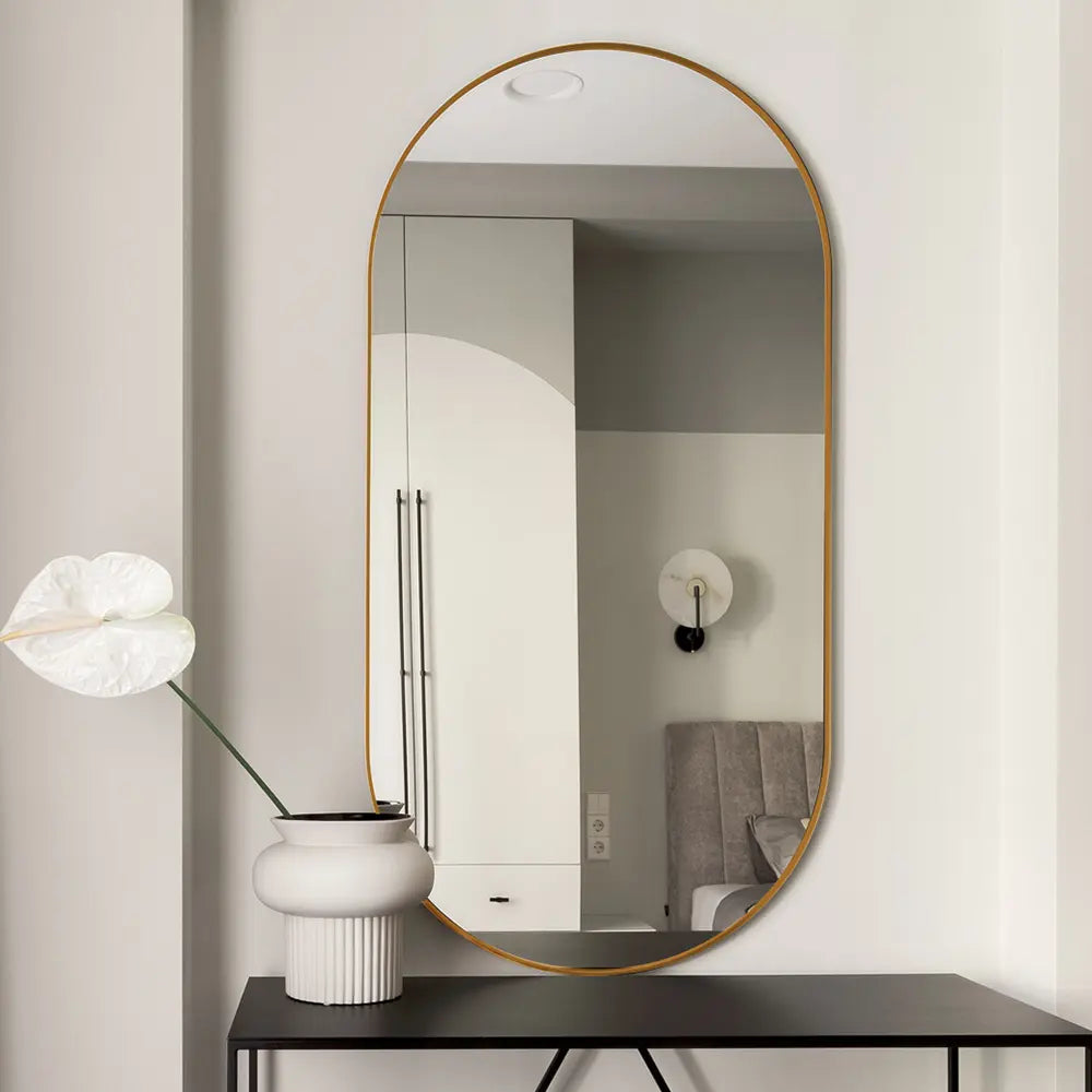 Bathroom featuring an oval aluminium-framed vanity mirror above a modern vanity