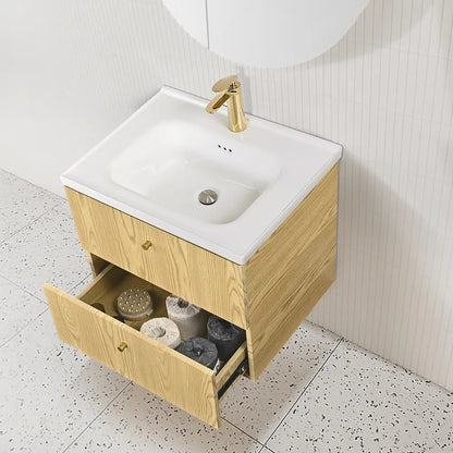 Bathroom vanity with open drawer, white sink, and gold faucet.
