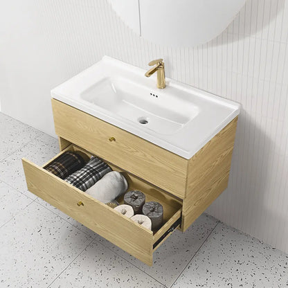 Bathroom vanity with open drawer containing towels and toiletries, gold faucet.