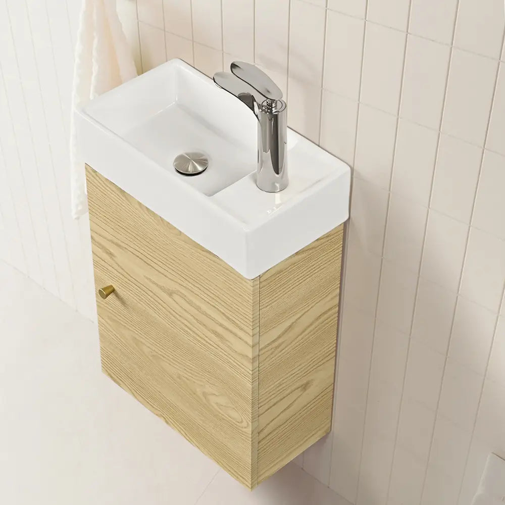 Bathroom vanity with white sink and wooden cabinet against a tiled wall.