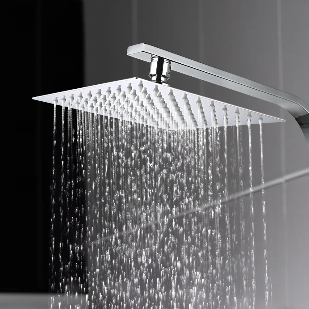 Chrome rain shower head with water droplets on a dark background