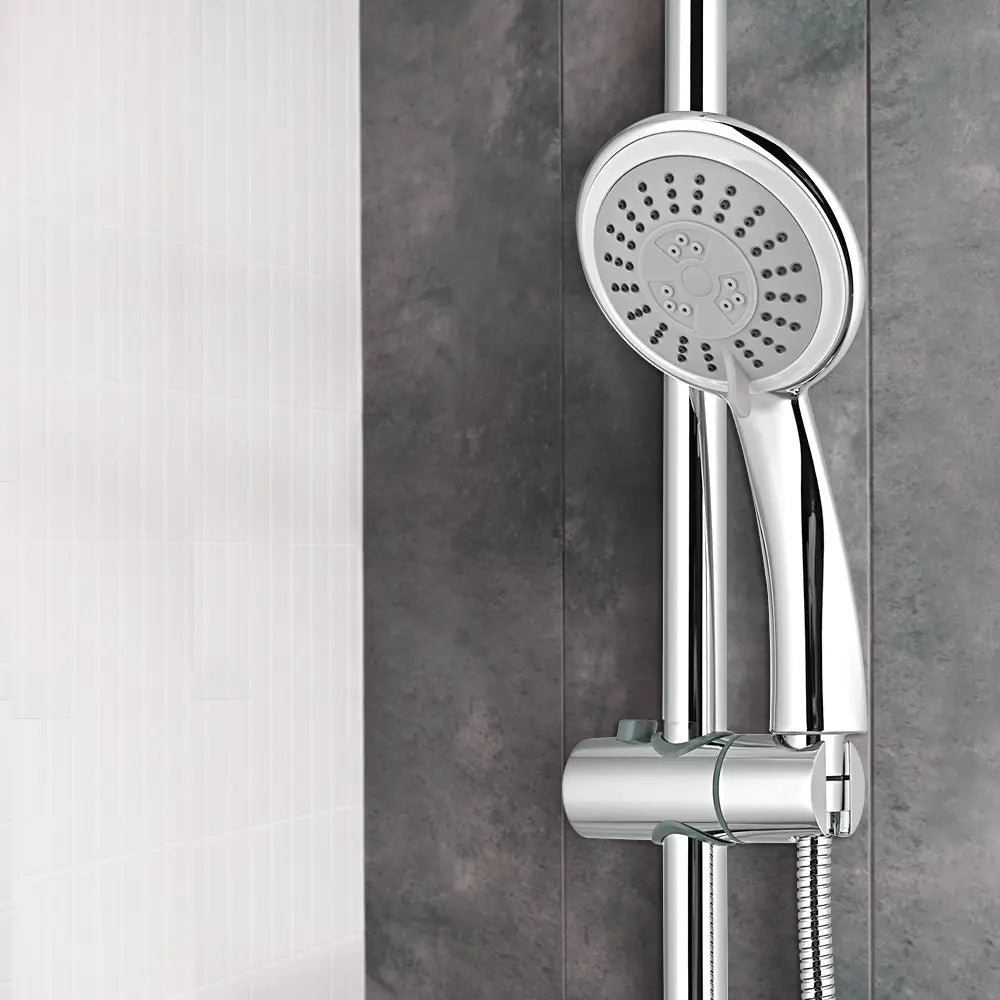 Chrome shower head and control handle mounted on a gray tiled wall.