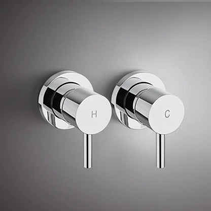 Wall-mounted chrome round shower mixer valve handles with hot and cold indicators on modern grey bathroom wall